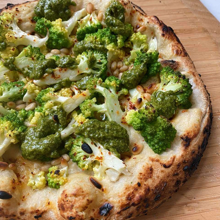 Pizza al romanesco con crema di anacardi, salsa verde e pinoli