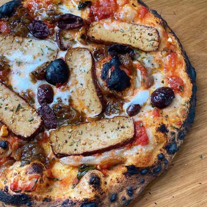 Pizza al tofu affumicato e alla cipolla caramellata con feta vegana, olive e rosmarino