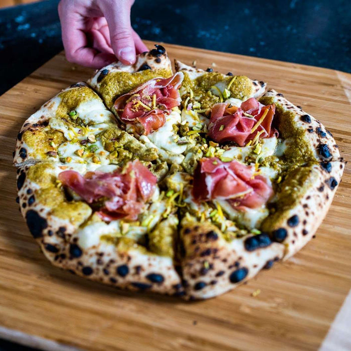 Pizza con crema al pistacchio, mozzarella, Pecorino e prosciutto crudo