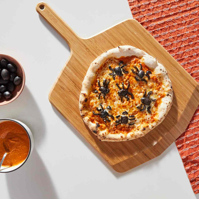 Pizza con olive a forma di ragno e salsa alla vodka