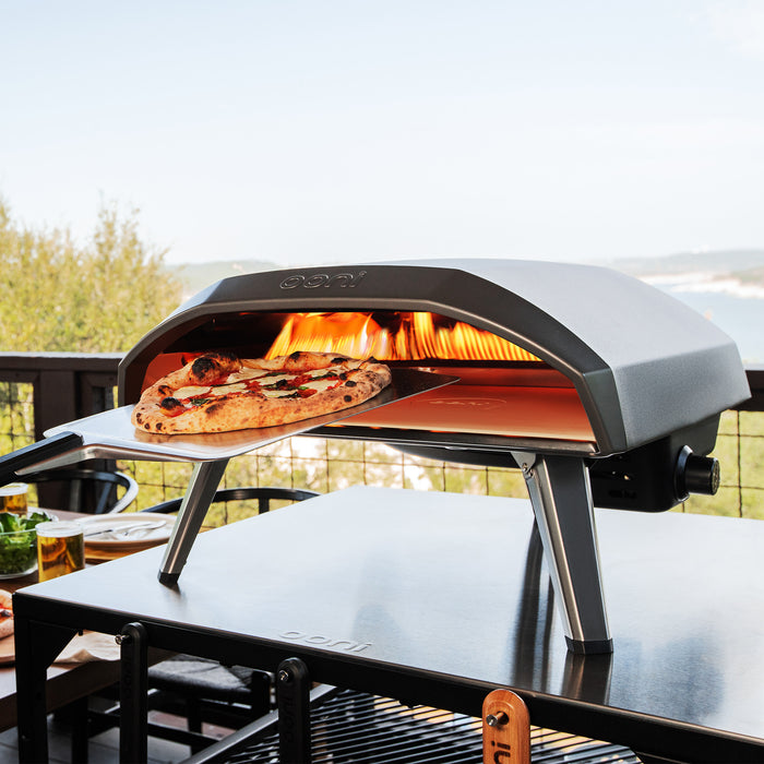 Koda 16 Pizza Oven with pizza peel on top of modular table | Clicca su questa immagine per aprire la modalità galleria immagini del prodotto. La modalità galleria immagini del prodotto consente di ingrandire le immagini.