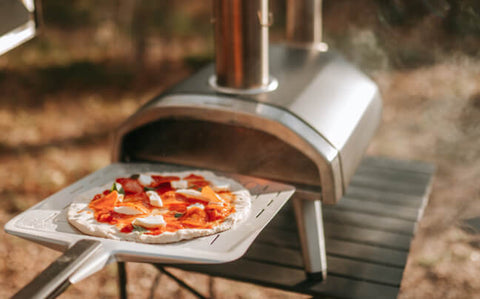 Ooni Karu 12 with a pizza on a peel